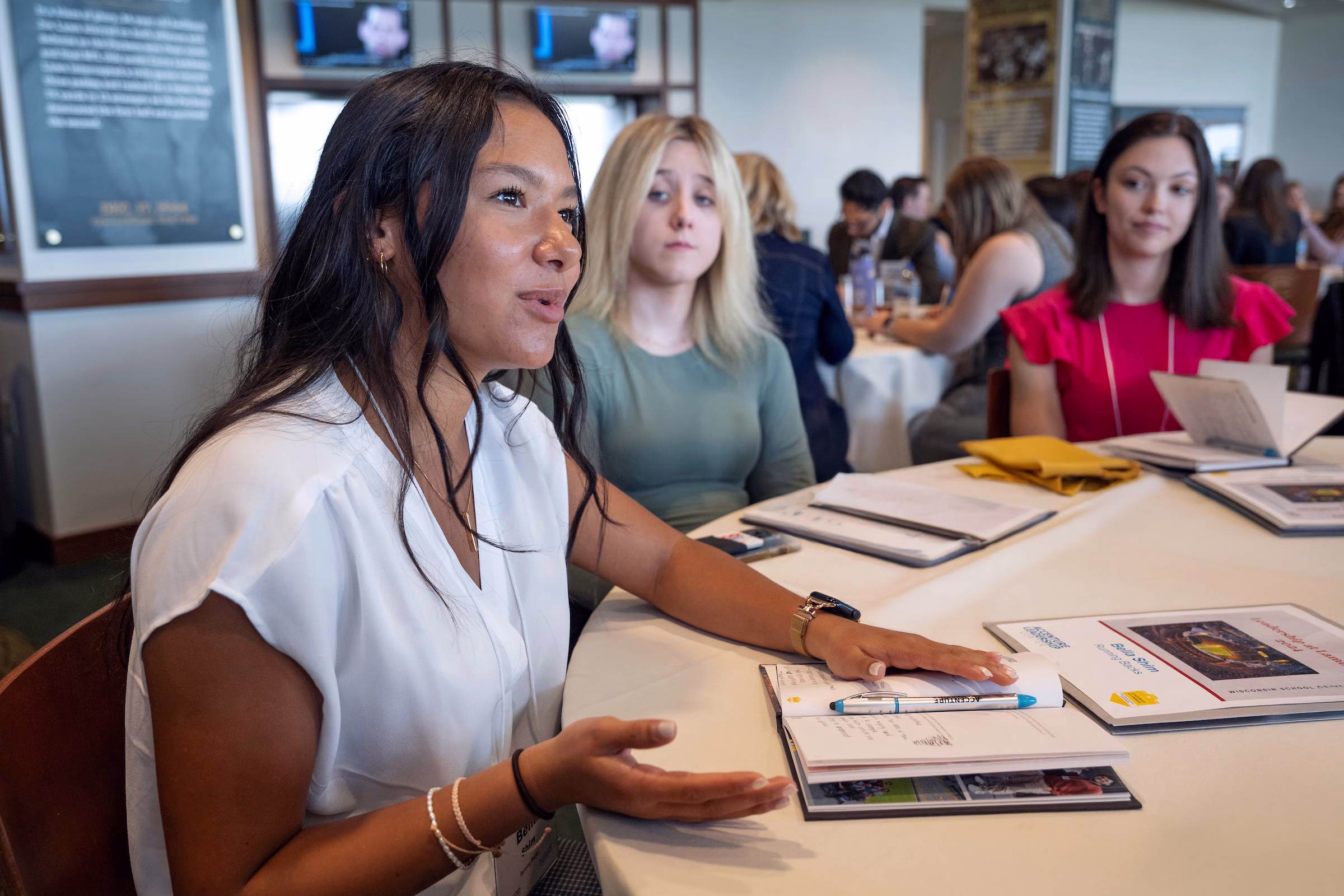 A woman speaking to the people sitting at her table