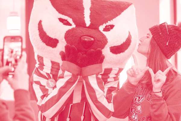 Bucky Badger posing for a photo with a fan.