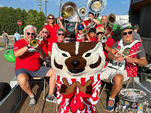 George Patterson poses for a photo with the UW Alumni band and Bucky Badger.
