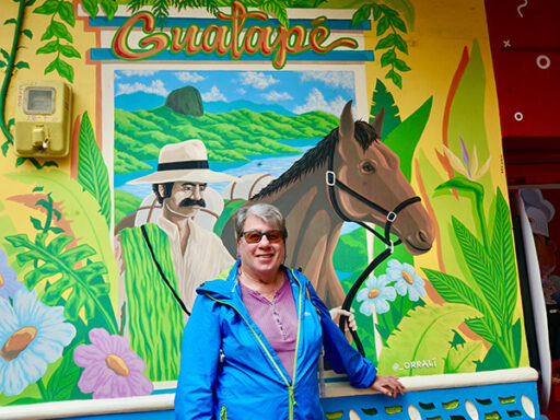 Carole Katz poses in front of a mural on one of her trips.