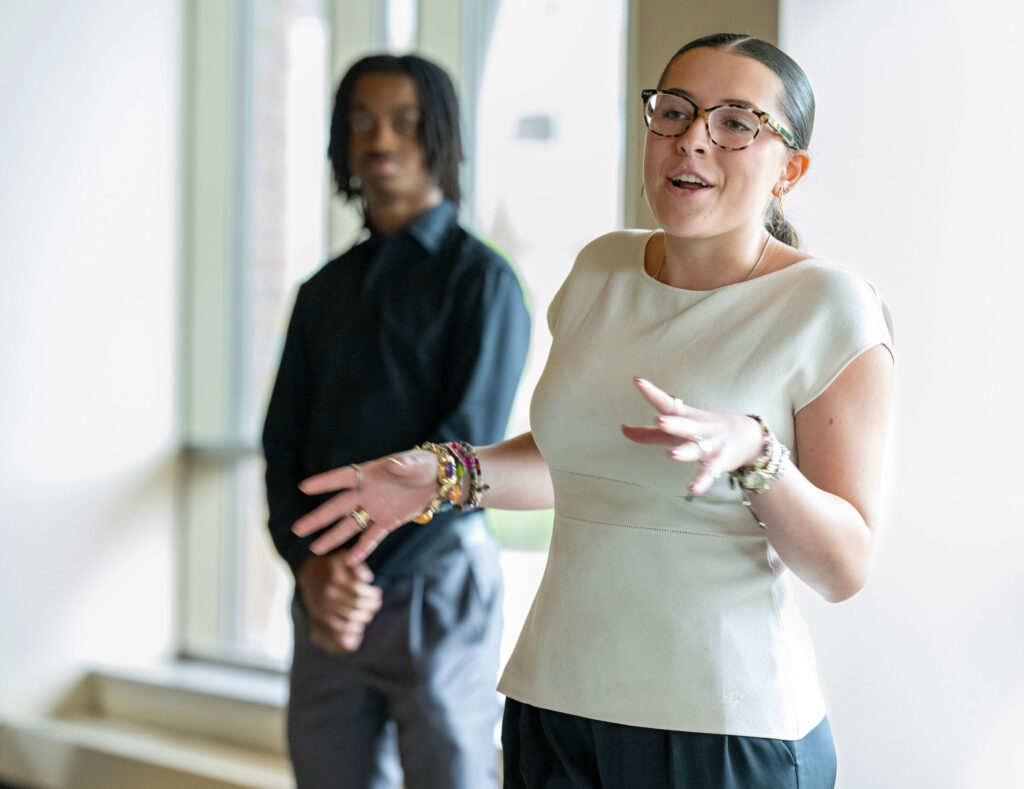 BEL Scholar Isabela Argote presents in a case competition as another student stands nearby.