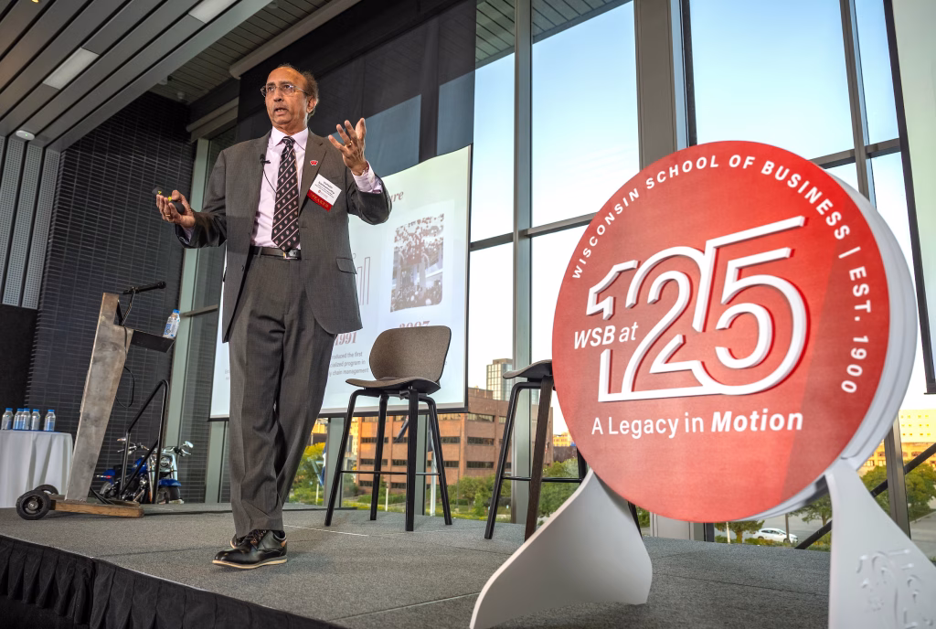 Dean Sambamurthy takes the stage next to a sign that reads WSB at 125: A Legacy in Motion.