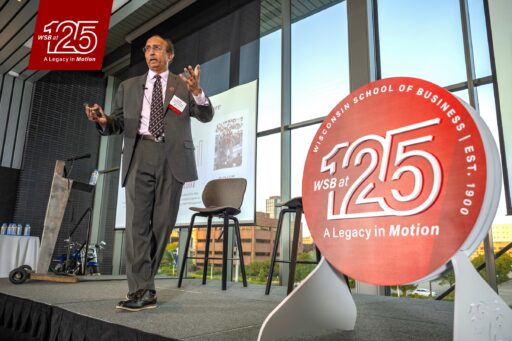 Dean Sambamurthy takes the stage next to a sign that reads WSB at 125: A Legacy in Motion.