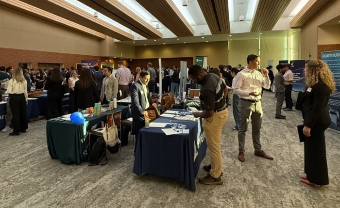 students and company representatives are engaging around skirted tables at the Risk and Insurance Department's Career Fair September 29, 2025