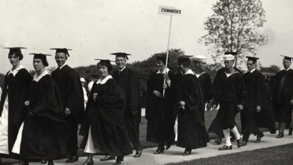 Business students in caps and gowns participate in the Spring 1918 graduation procession.