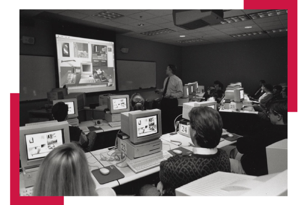 A black and white photo of a professor teaching a class.