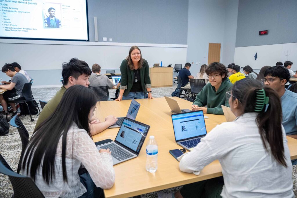 Students work around a table in Amber Field's CDIS capstone class