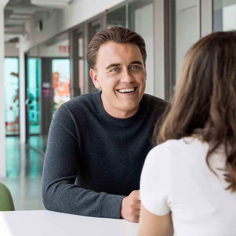 Anders smiling at his coworker.