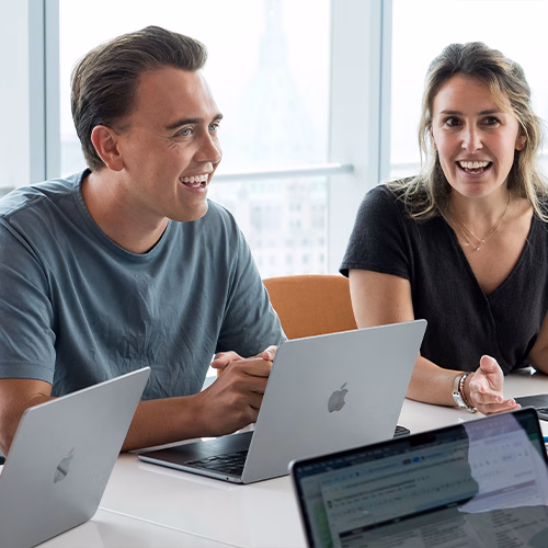 Anders smiling and talking with his coworkers in a meeting.