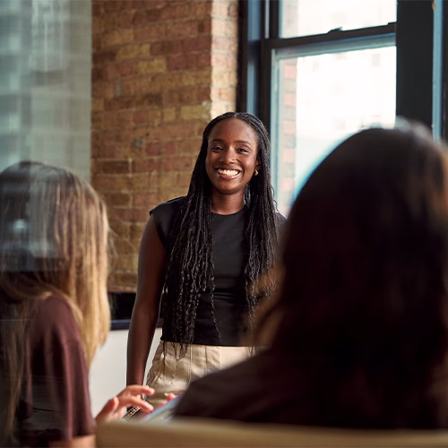 Oumou smiling at her coworkers at a meeting.