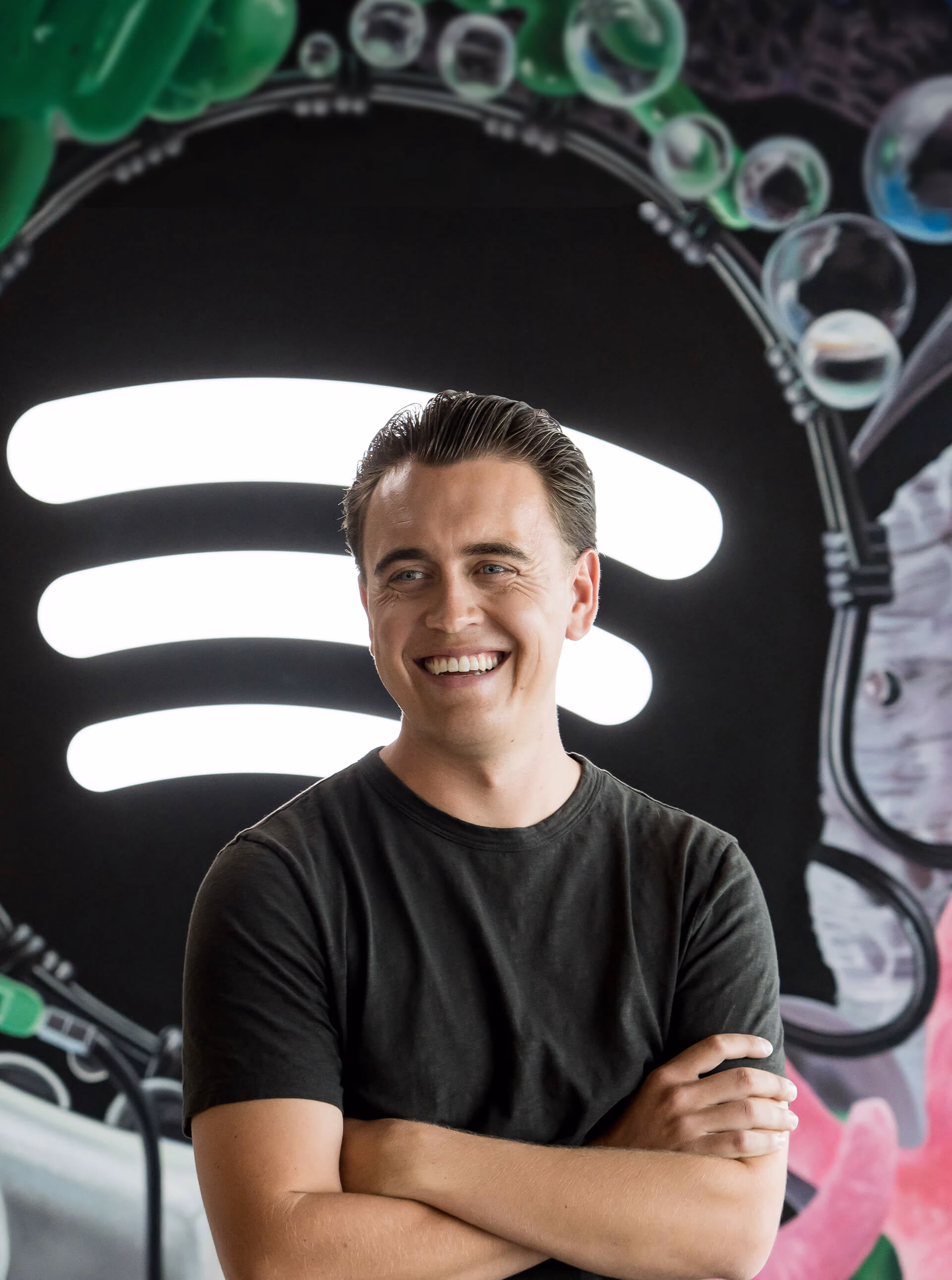 Anders laughing as he stands in front of the Spotify logo.