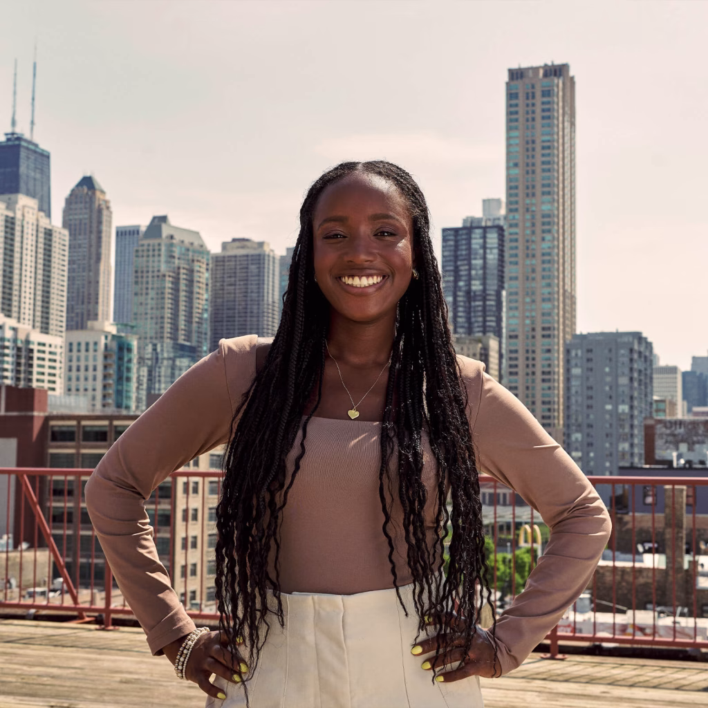 Oumou confidently smiling in front of a skyline.