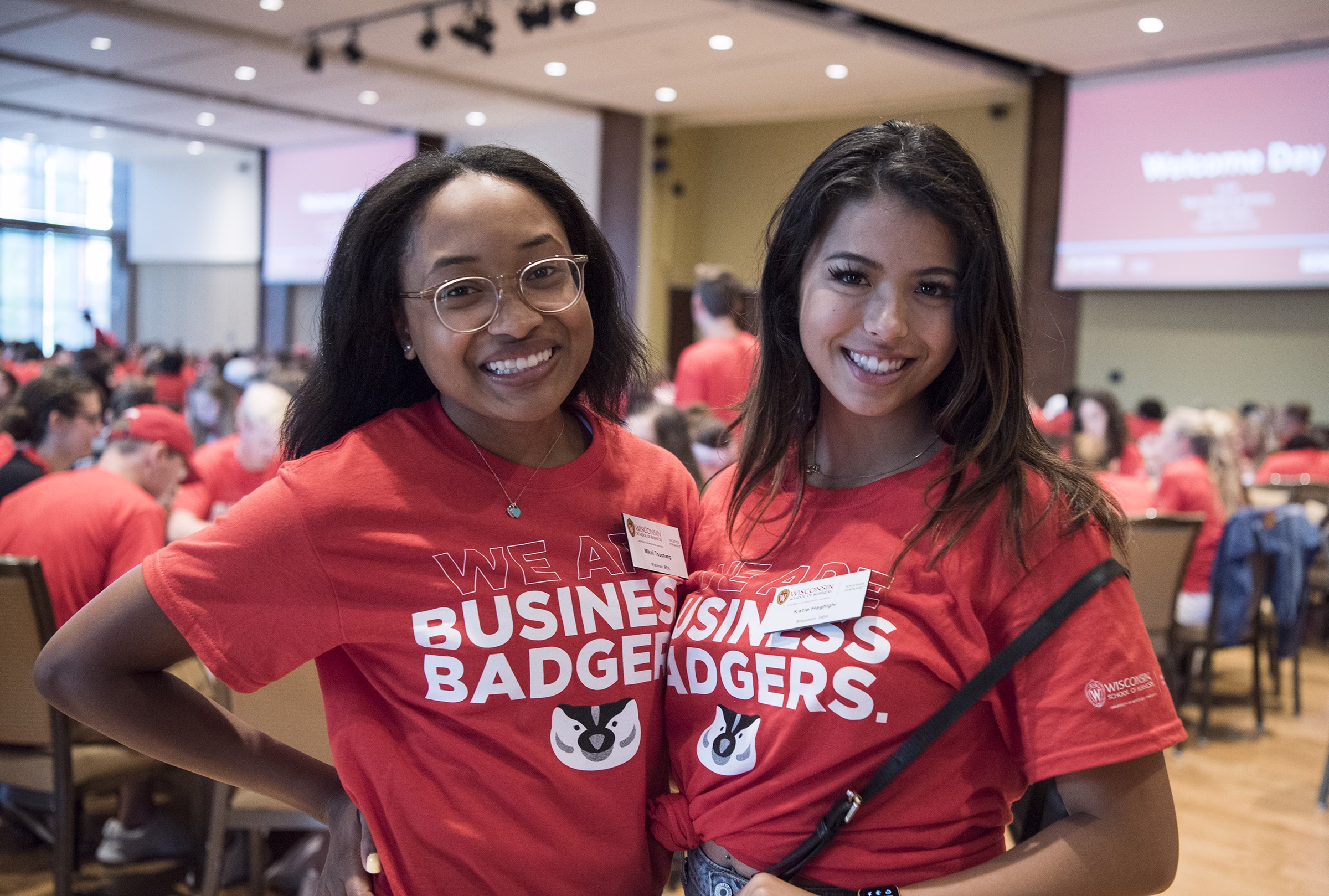 Two students smiling in Business Badger shirts.
