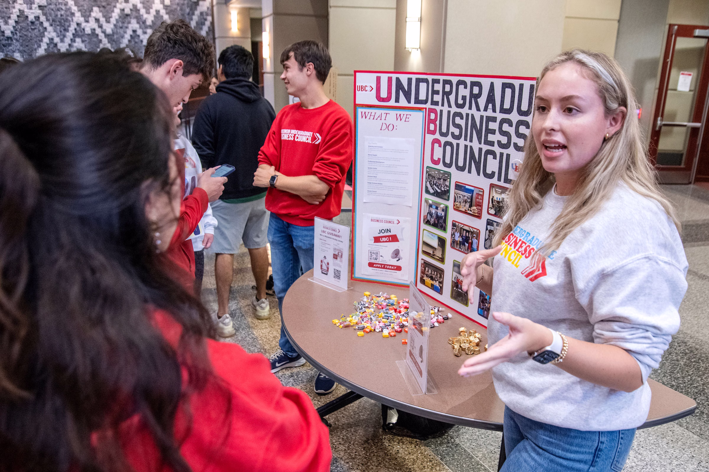 A woman talks to students about the Undergrad Business Council group during the BBA Student Org Fair.