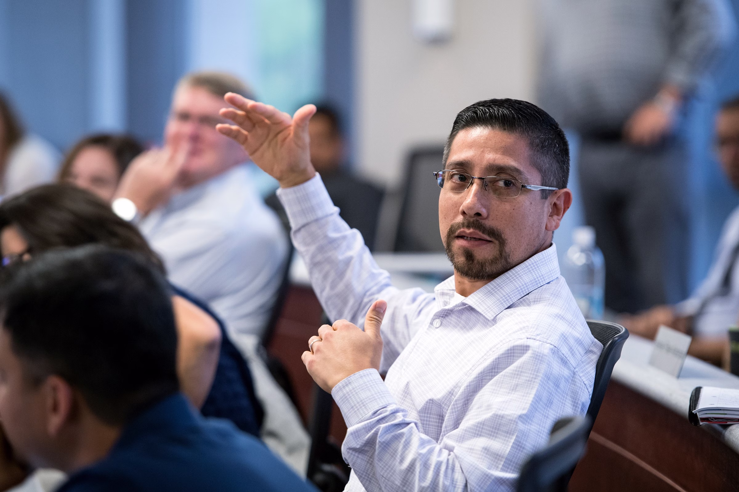 A man sitting and gesturing with his hands as he talks.