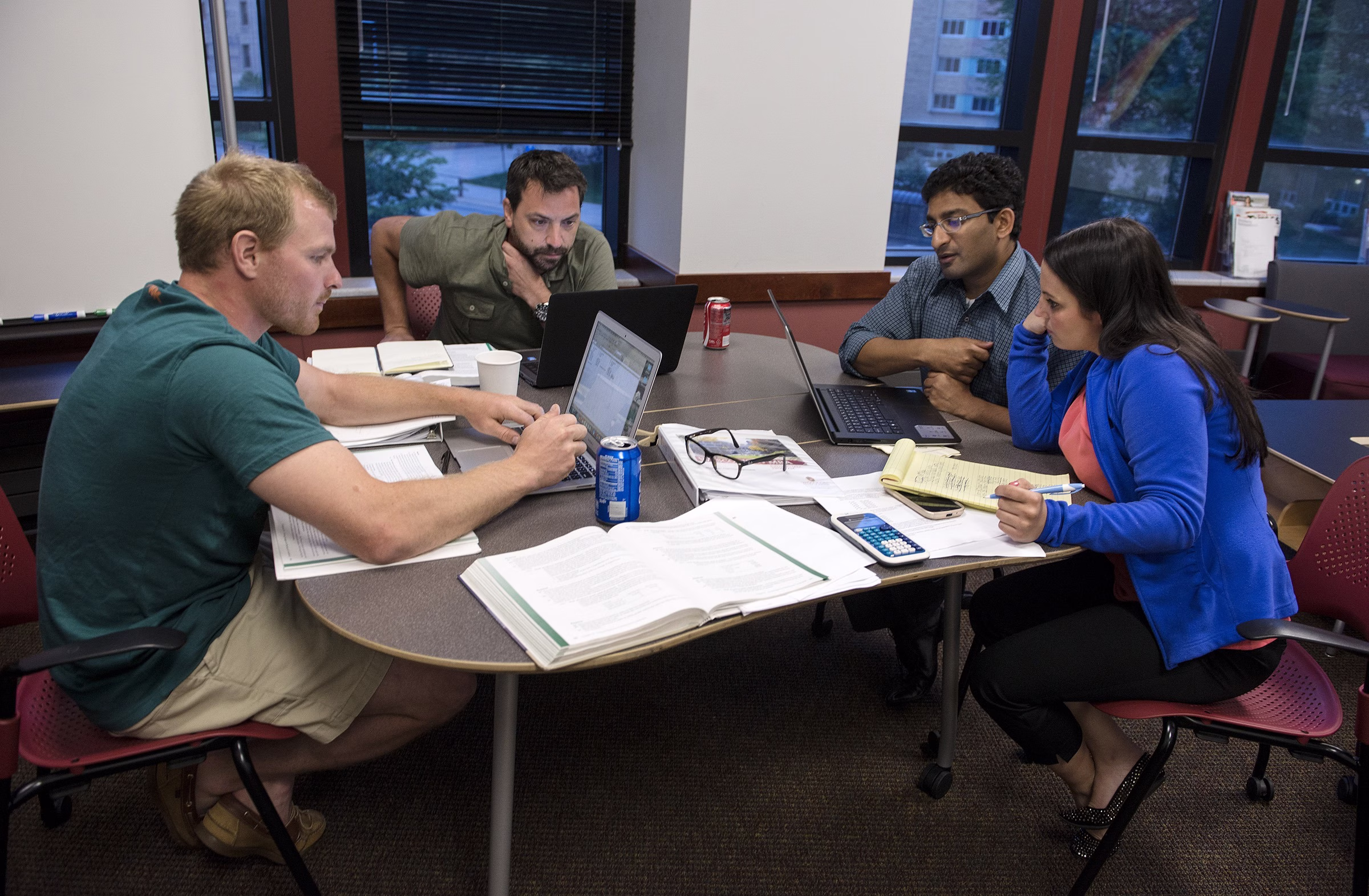 Evening MBA students (L to R) Ryan Wagner, Keith Boucher, Aroon Viswanathan and Katie Kapler breaks into their group to work on a problem.