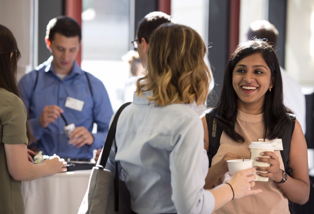 People talking at the Experience Week Check In station.