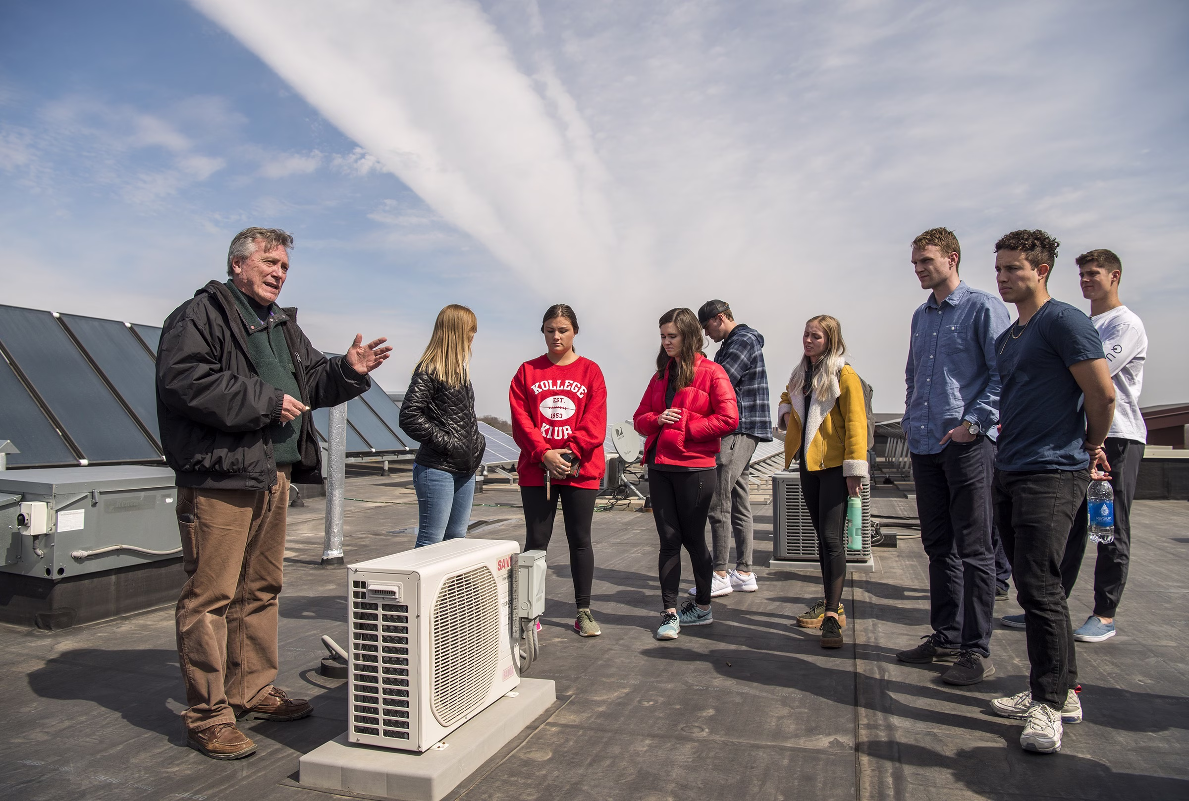 Tom Landgraf speaks to his students on a rooftop at a field trip.