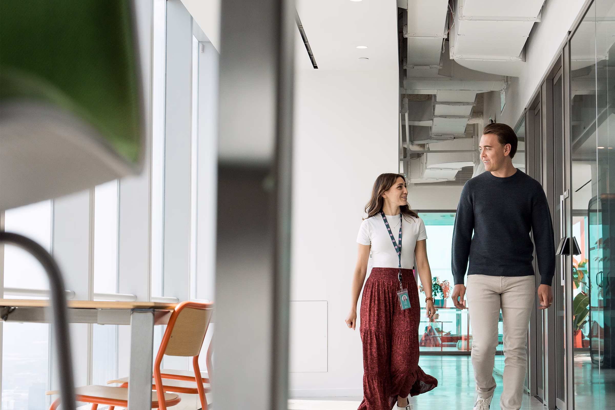 A man and a woman walking in a hallway.