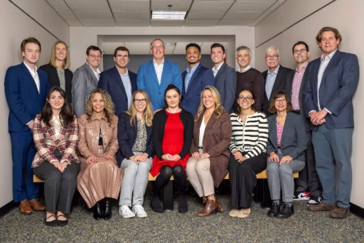 Members of the 2025-26 RMI MBA Advisory Board pose for a photo with MBA students and some faculty and staff. Eighteen people are in the photo.