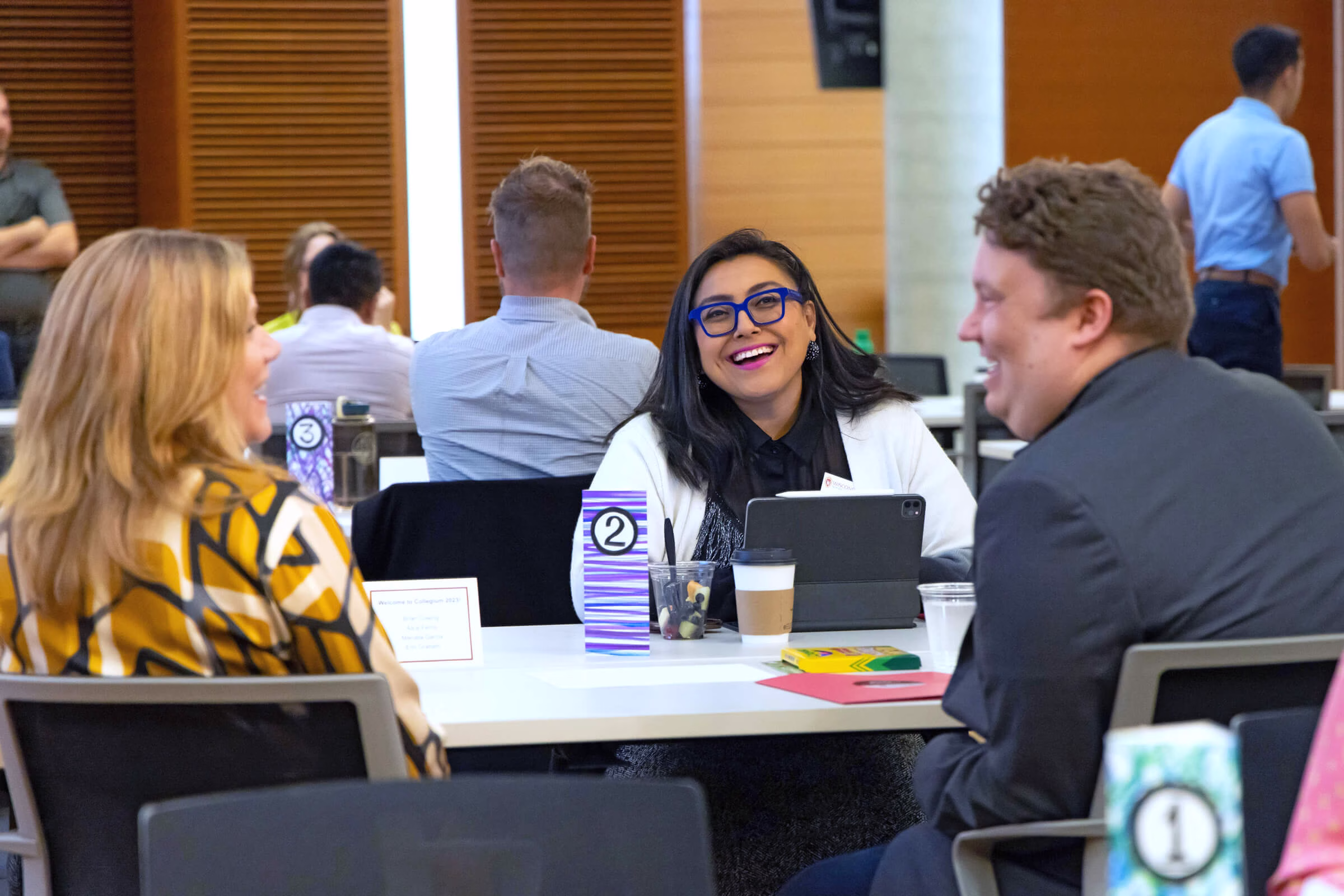 Two women and one man sitting at a table and laughing.