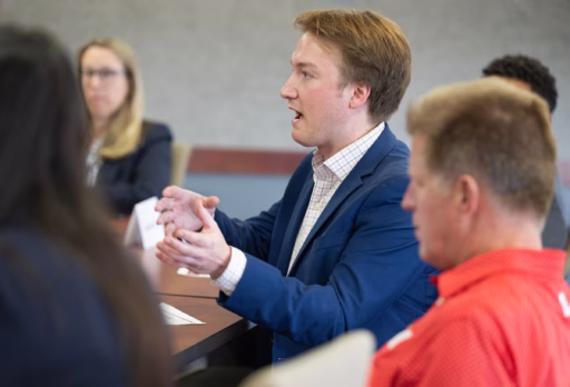 Hayden Robinson is talking during the 2024 RMI MBA Advisory Board meeting. Also seated at the table are Melissa Leuck and Dan Kelly.