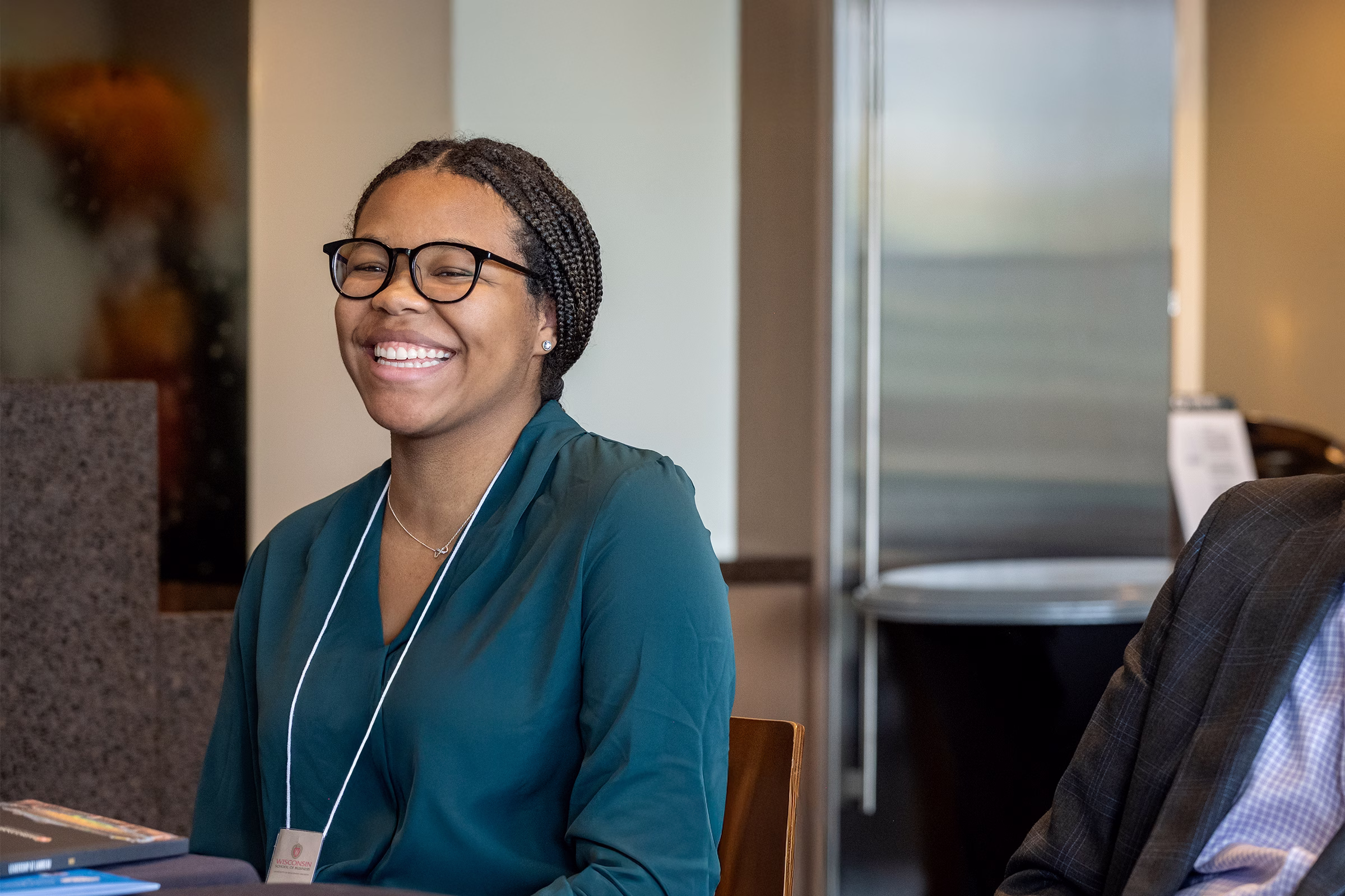 A female student laughs while sitting next to Dean Sambamurthy.