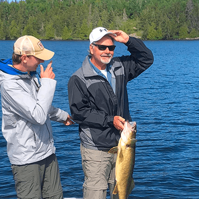 Steven McCosky on the water, holding a large fish.