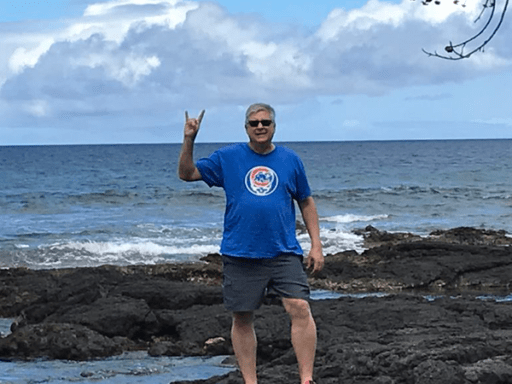 Ron Kral posing in front of a shore.