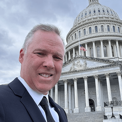 Don Nelson in a suit in front of the capitol building.