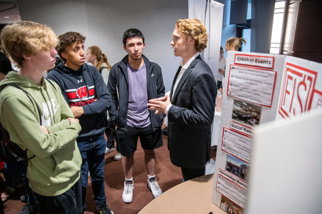 Four students talking at the student organization fair.