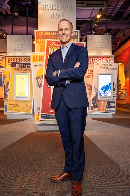 Steve standing proudly in front of old Hershey's ads.
