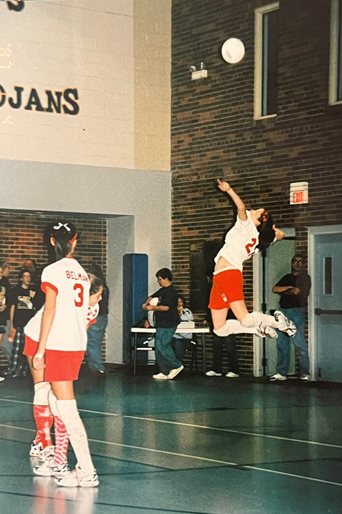 Annemarie jumping up to hit a volleyball midair.