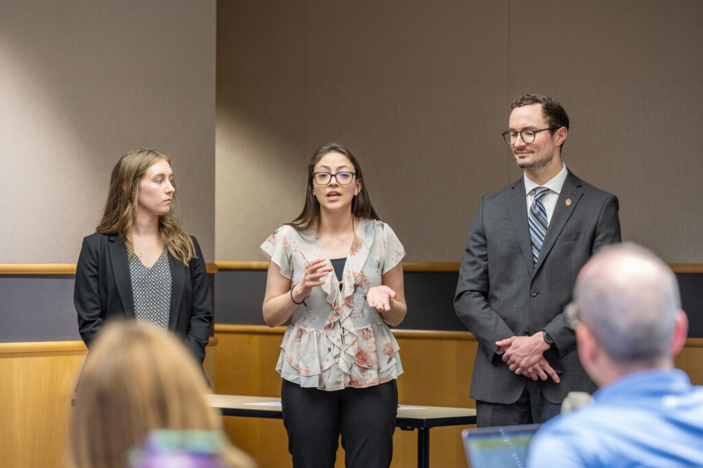 Three students present their ideas at the Reverse Pitch competition.