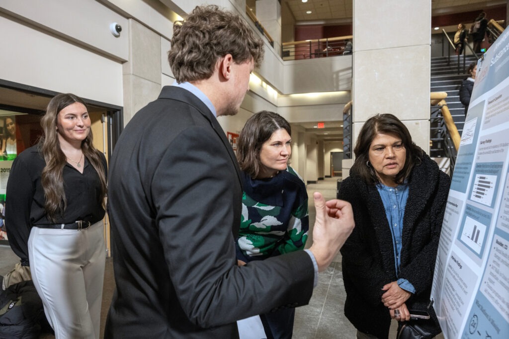 A student shares his project at a poster session.