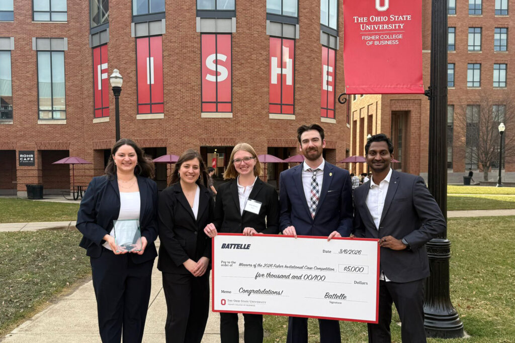 Five students stand outside and hold a $5,000 check for winning the 2026 Fisher College case competition.