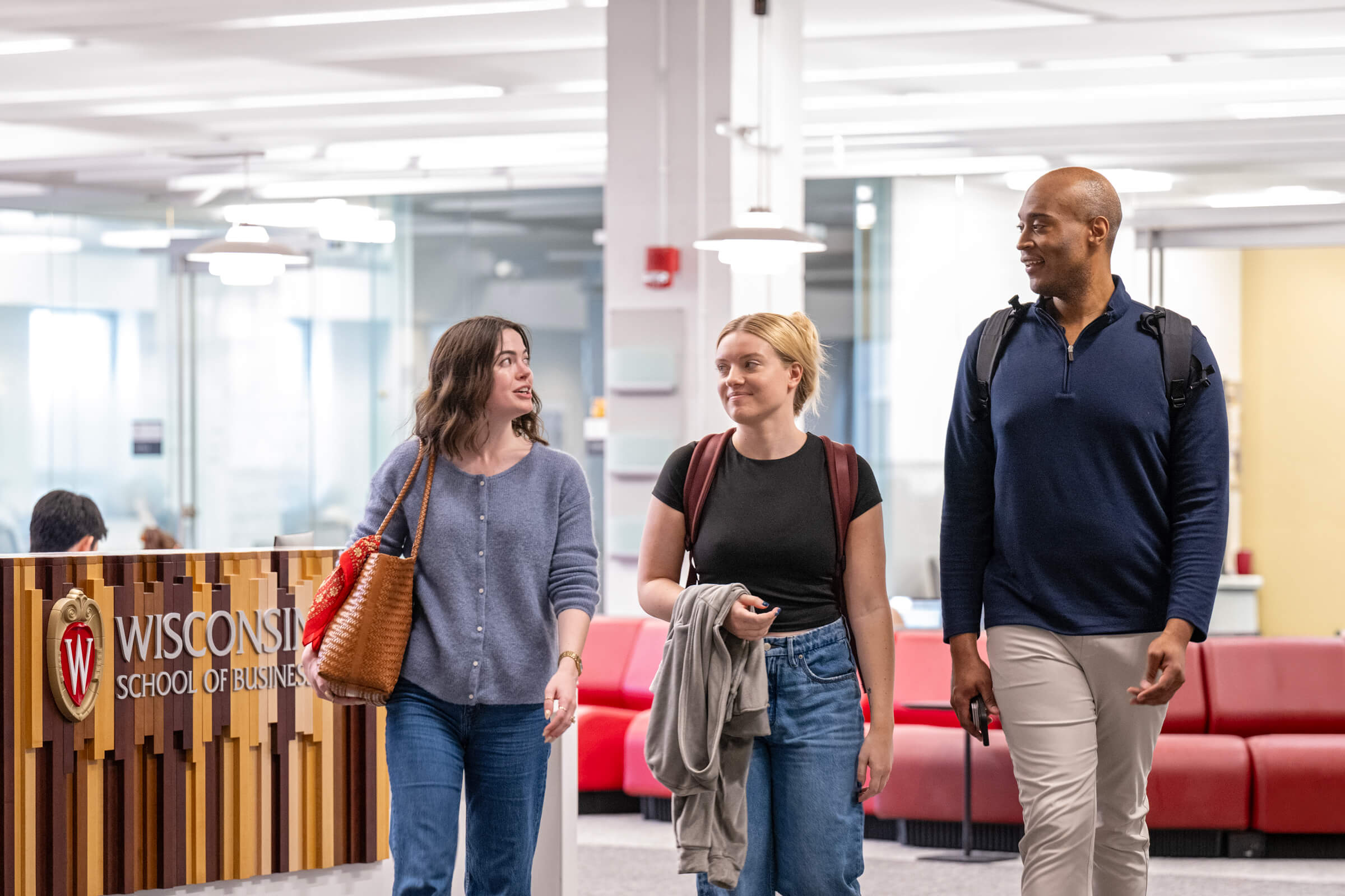 Three students walking and talking in Grainger Hall..