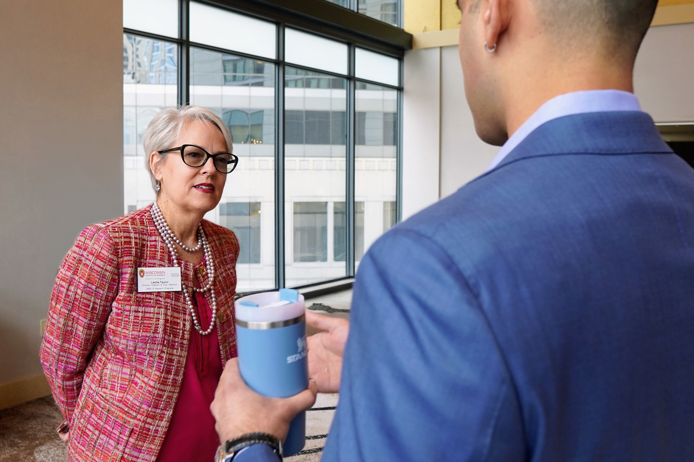 Leslie Taylor listening to a student in a suit.