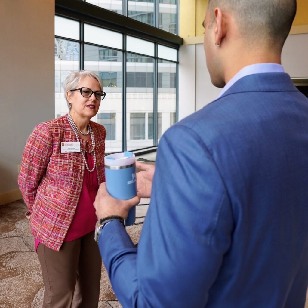 Leslie Taylor listening to a student in a suit.