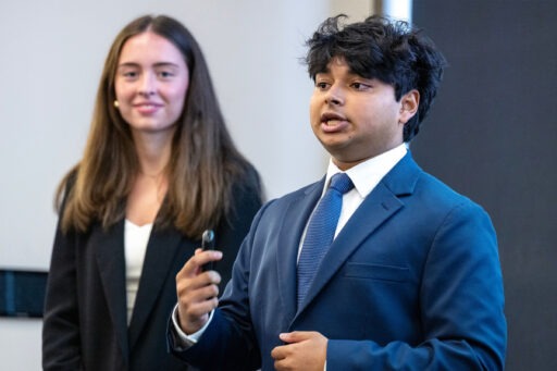 Lucia Fuentes (left) and Rohan Dileep (right) talking into a hand held microphone.