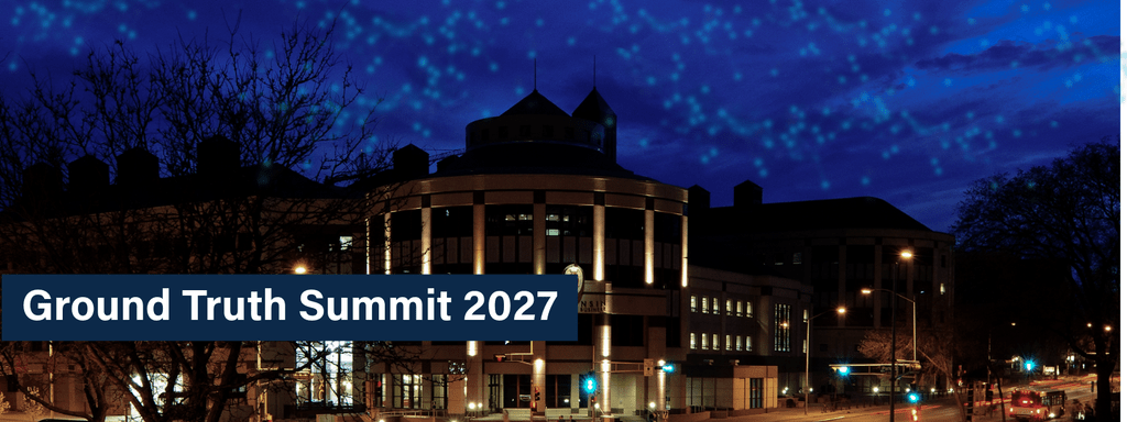 Image of Wisconsin School of Business at night with a Ground Truth Summit 2027 banner