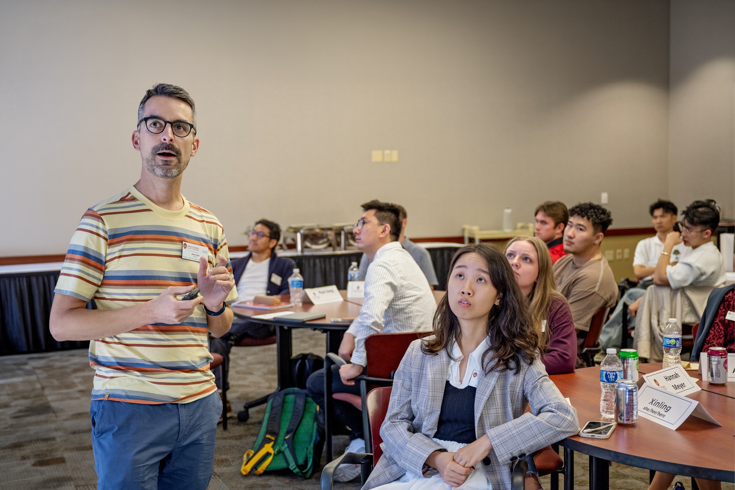 Jake Dean standing in front of students who are sitting at tables.