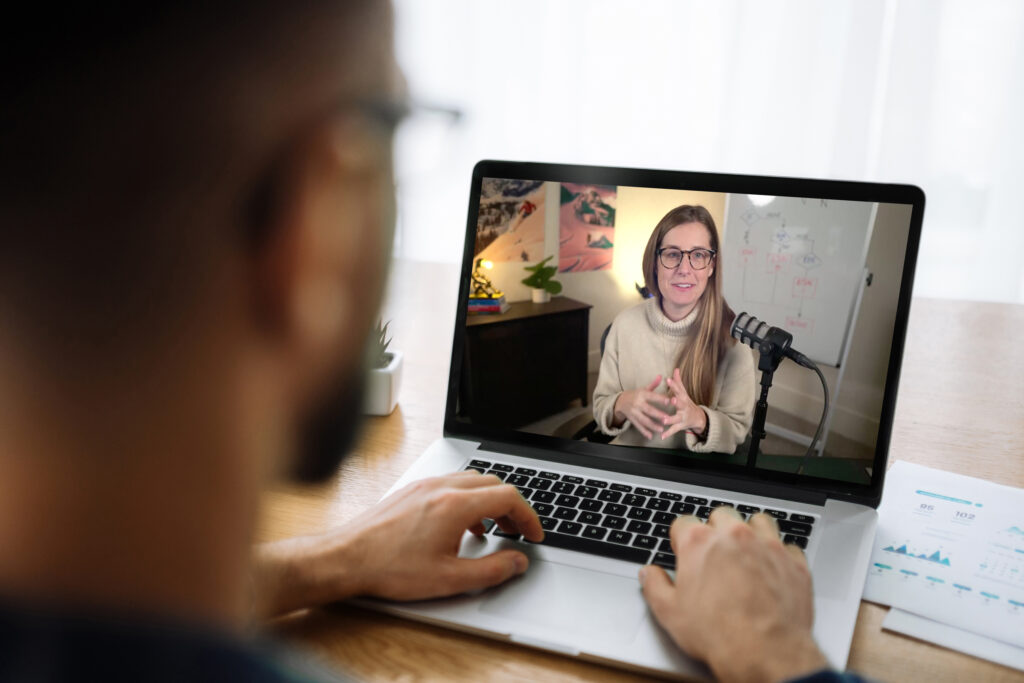 Student watching instructor Katie Gaertner livestream class on his laptop.