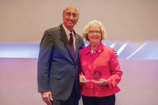 Cynthia “Cindy” Ihlenfeld holds her WSB Alumni Award while standing next to Dean Samba.