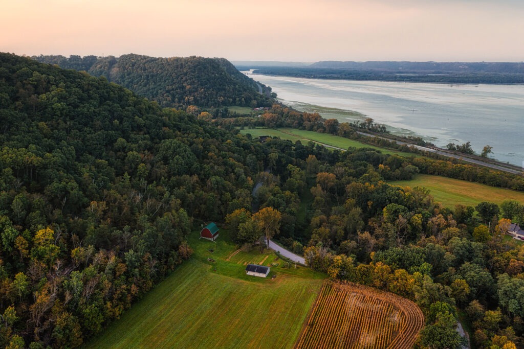 Aerial view of farmland amongst trees.